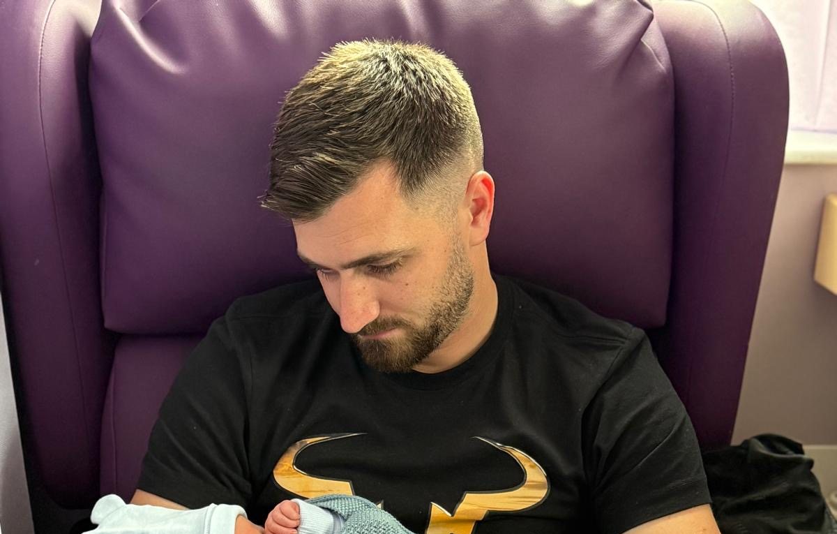Gregory Cooke holding his newborn son Romeo