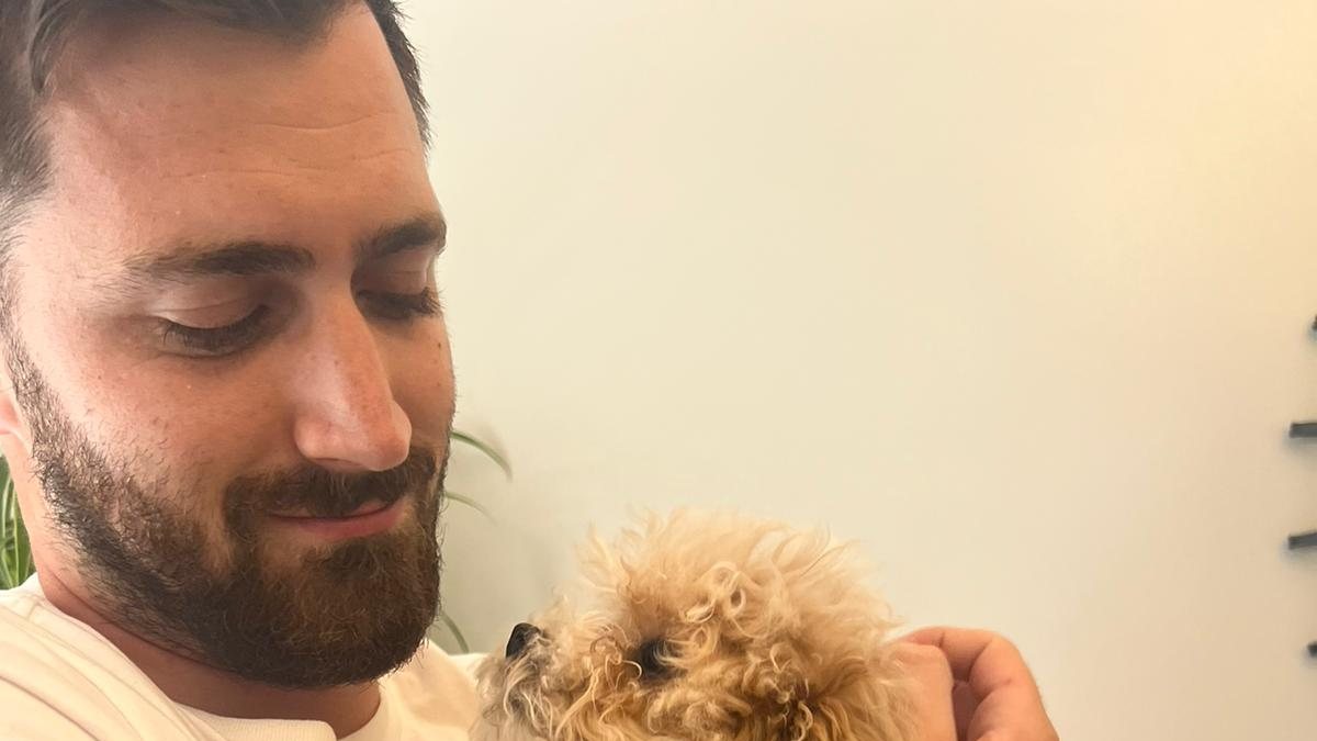 Greg at home with one of his dogs